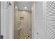 Stylish, tiled shower with a glass door, a built-in seat, and mosaic floor at 1100 Tarpon Center Dr # 104, Venice, FL 34285