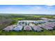 Picturesque aerial view of homes arranged around a cul-de-sac and pond, nestled amidst lush greenery and serene lakes at 11239 Boundless Ter, Venice, FL 34293