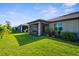 Lush backyard landscaping with screened-in patios, vibrant green grass, and tropical plants at 11239 Boundless Ter, Venice, FL 34293