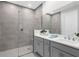 Modern bathroom with a walk-in shower, dual sink vanity, gray finishes, and plenty of counter space at 11239 Boundless Ter, Venice, FL 34293