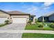 Inviting home exterior featuring a paved driveway, a two-car garage, and beautifully landscaped yard at 11239 Boundless Ter, Venice, FL 34293