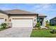 Charming home featuring a well-manicured lawn, paved driveway, and a two-car garage at 11239 Boundless Ter, Venice, FL 34293