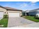 Charming home exterior with a paved driveway, well-manicured lawn, and attached two-car garage at 11239 Boundless Ter, Venice, FL 34293