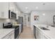 The kitchen features white cabinets, a tile backsplash, and stainless steel appliances at 11239 Boundless Ter, Venice, FL 34293