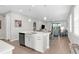 Modern open-concept kitchen with a central island featuring a sink and dishwasher at 11239 Boundless Ter, Venice, FL 34293