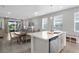 The kitchen island features stainless steel appliances and opens to the dining and living areas at 11239 Boundless Ter, Venice, FL 34293