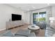 Bright living room featuring neutral tones, tile flooring, and sliding glass doors leading to the outdoor space at 11239 Boundless Ter, Venice, FL 34293