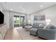 Comfortable living area features stylish furniture, tile flooring, and access to the outdoors through sliding glass doors at 11239 Boundless Ter, Venice, FL 34293