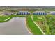 An aerial view showcases condo buildings overlooking a serene lake, golf course, and verdant landscape at 12140 Wellen Golf St # 401, Venice, FL 34293