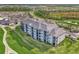 Attractive three-story condo building with balconies, lush landscaping, and stunning golf course views at 12140 Wellen Golf St # 401, Venice, FL 34293