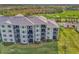 Elegant three-story condo building showcasing multiple balconies, manicured lawns, and covered parking at 12140 Wellen Golf St # 401, Venice, FL 34293