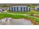 Elegant condo building overlooking meticulously maintained greenery, a pond, and landscaped walking paths at 12140 Wellen Golf St # 401, Venice, FL 34293
