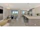 Open-concept living and kitchen area with modern finishes, island seating, and natural light at 12140 Wellen Golf St # 401, Venice, FL 34293