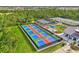 Aerial shot showcases multiple pickleball courts with players, shaded seating, and vibrant landscaping at 12140 Wellen Golf St # 401, Venice, FL 34293