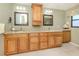 Bathroom with dual sinks, granite countertops, and beautiful wood cabinetry at 1229 Waterside Ln, Venice, FL 34285