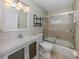 Well-lit bathroom featuring a tub with glass door, modern vanity, and neutral color scheme at 1234 Pinebrook Way, Venice, FL 34285