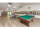 The game room in the community clubhouse features a pool table, ping pong table, bookshelf, and interesting artwork on the walls at 1234 Pinebrook Way, Venice, FL 34285