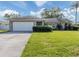 Charming single story home featuring an attached garage and well-manicured front yard at 1234 Pinebrook Way, Venice, FL 34285