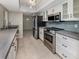 Well-lit kitchen with stainless steel appliances, tile backsplash, and sleek white cabinetry at 1234 Pinebrook Way, Venice, FL 34285