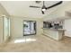 Open-concept living space with tile floors, sliding glass doors, and adjacent breakfast bar with kitchen at 1234 Pinebrook Way, Venice, FL 34285