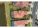 Overhead view of home with screened patio, red roof, and surrounding lush landscaping at 1254 Cielo Ct, North Venice, FL 34275