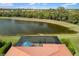 Aerial view of screened-in patio and red tile roof overlooking the lake at 1254 Cielo Ct, North Venice, FL 34275