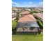 Home aerial view showcases a screened patio and red tile roof in a lush community at 1254 Cielo Ct, North Venice, FL 34275