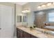 Bathroom featuring double sinks, vanity with granite countertop and large mirror at 1254 Cielo Ct, North Venice, FL 34275