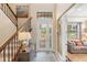 Bright foyer with high ceilings, decorative glass door, staircase and stylish console table at 1254 Cielo Ct, North Venice, FL 34275