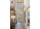 Bright foyer with high ceilings, decorative glass door, staircase and stylish console table at 1254 Cielo Ct, North Venice, FL 34275