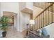 Open foyer with elegant staircase, tiled flooring, and view into the living room and dining area at 1254 Cielo Ct, North Venice, FL 34275