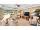 Cozy living room features tray ceilings, plush seating, and views of the outdoor pond at 1254 Cielo Ct, North Venice, FL 34275