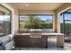 Covered outdoor kitchen with a grill, sink, and mini-refrigerator, perfect for entertaining at 1254 Cielo Ct, North Venice, FL 34275