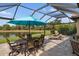 This screened-in patio features dining and lounge areas with a tranquil lake view at 1254 Cielo Ct, North Venice, FL 34275
