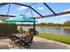 Screened-in patio features a dining table with seating and a beautiful lake view at 1254 Cielo Ct, North Venice, FL 34275