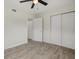 Bright bedroom featuring modern ceiling fan, wood-look tile flooring, and white closet doors at 1258 Barbara Dr # 105, Venice, FL 34285