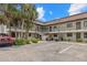 Condominium building with two stories, palm trees, and ample parking spots at 1258 Barbara Dr # 105, Venice, FL 34285