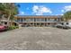 Condominium building with two stories, palm trees, and ample parking spots at 1258 Barbara Dr # 105, Venice, FL 34285