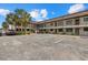 Condominium building with two stories, palm trees, and ample parking spots at 1258 Barbara Dr # 105, Venice, FL 34285