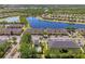 Aerial view of lakefront community with townhomes, swimming pool, lush landscaping and convenient parking at 12983 Tigers Eye Dr, Venice, FL 34292