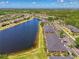 Expansive aerial view showcasing the community, adjacent lake, and lush surroundings at 12983 Tigers Eye Dr, Venice, FL 34292