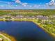Aerial view of waterfront townhome community, and tree lined streets along a serene lake at 12983 Tigers Eye Dr, Venice, FL 34292