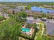 Aerial shot of a refreshing community pool surrounded by tropical landscaping, townhomes, and manicured grounds at 12983 Tigers Eye Dr, Venice, FL 34292