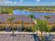 Inviting two-story townhome with lush palm trees and convenient parking, set against a serene lake view at 12983 Tigers Eye Dr, Venice, FL 34292