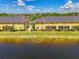A charming, yellow condominium building overlooks a serene lake and beautifully maintained landscaping at 12983 Tigers Eye Dr, Venice, FL 34292