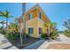 Corner unit with bright yellow exterior, well-kept landscaping, and sidewalk access at 12983 Tigers Eye Dr, Venice, FL 34292