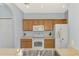 Bright kitchen with white appliances, wooden cabinets, and neutral countertops at 12983 Tigers Eye Dr, Venice, FL 34292