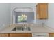 Kitchen with stainless steel sink and view to outdoor through an arched opening to a living area at 12983 Tigers Eye Dr, Venice, FL 34292