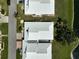 Close aerial of the villa's roofs, yard, and water feature at 131 Sandstone Cir, Venice, FL 34293