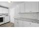 Laundry room featuring white cabinets, granite countertops, and new washer and dryer at 131 Sandstone Cir, Venice, FL 34293